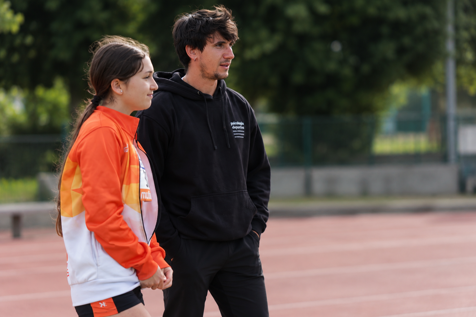 Ferran Merino junto a una deportista en una pista de atletismo